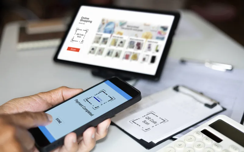 close up shot, man hand using smart phone to make mobile wallet successfully payment code scanning on the invoice used for payment instead of cash<br />